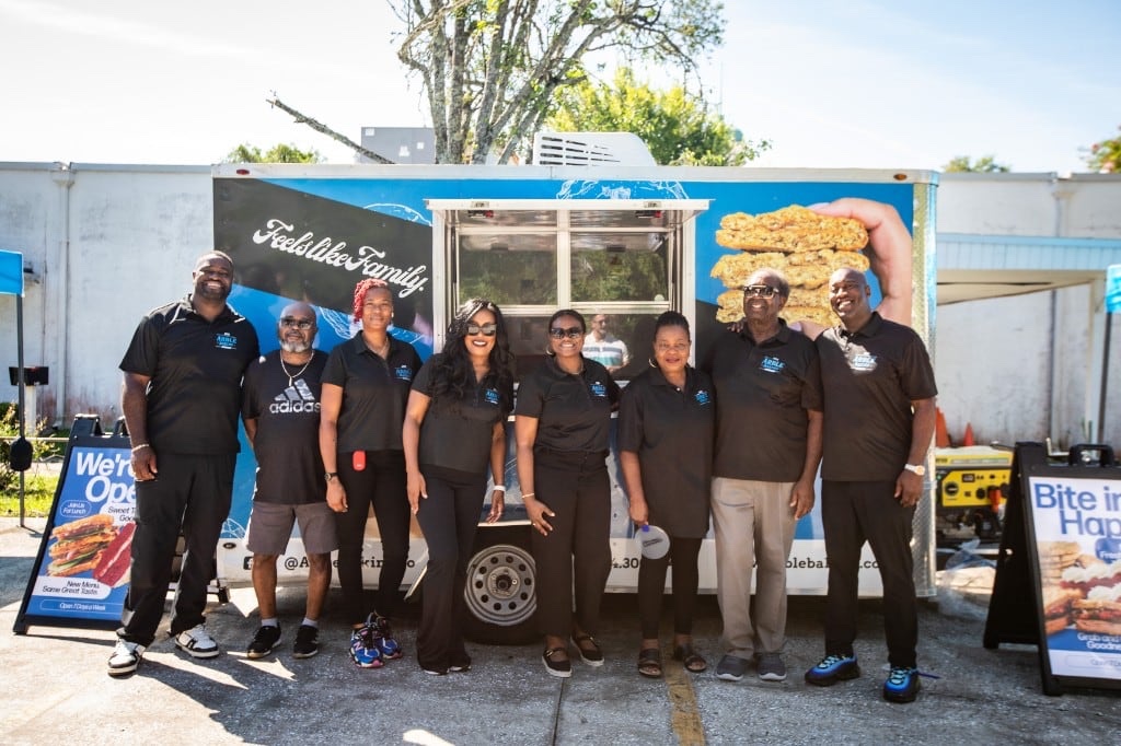 The Anderson family and Arble team standing together in front of the food truck at a Jacksonville community event