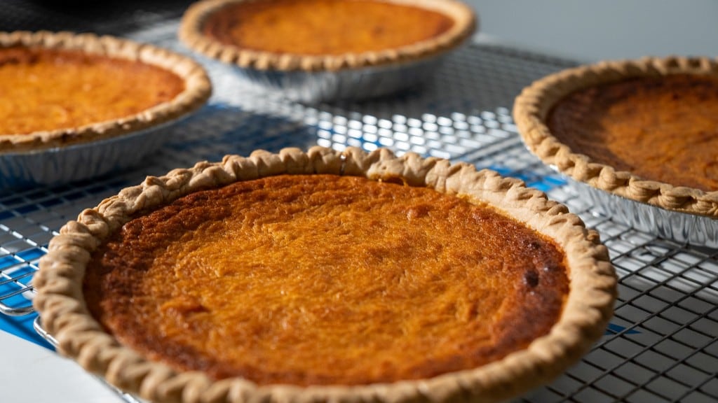 Several whole sweet potato pies cooling on bakery racks at Arble