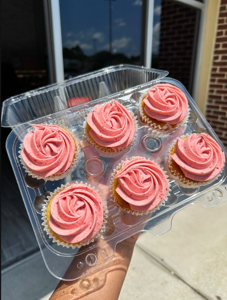 Six Arble mini cupcakes topped with pink swirled frosting in a clear container