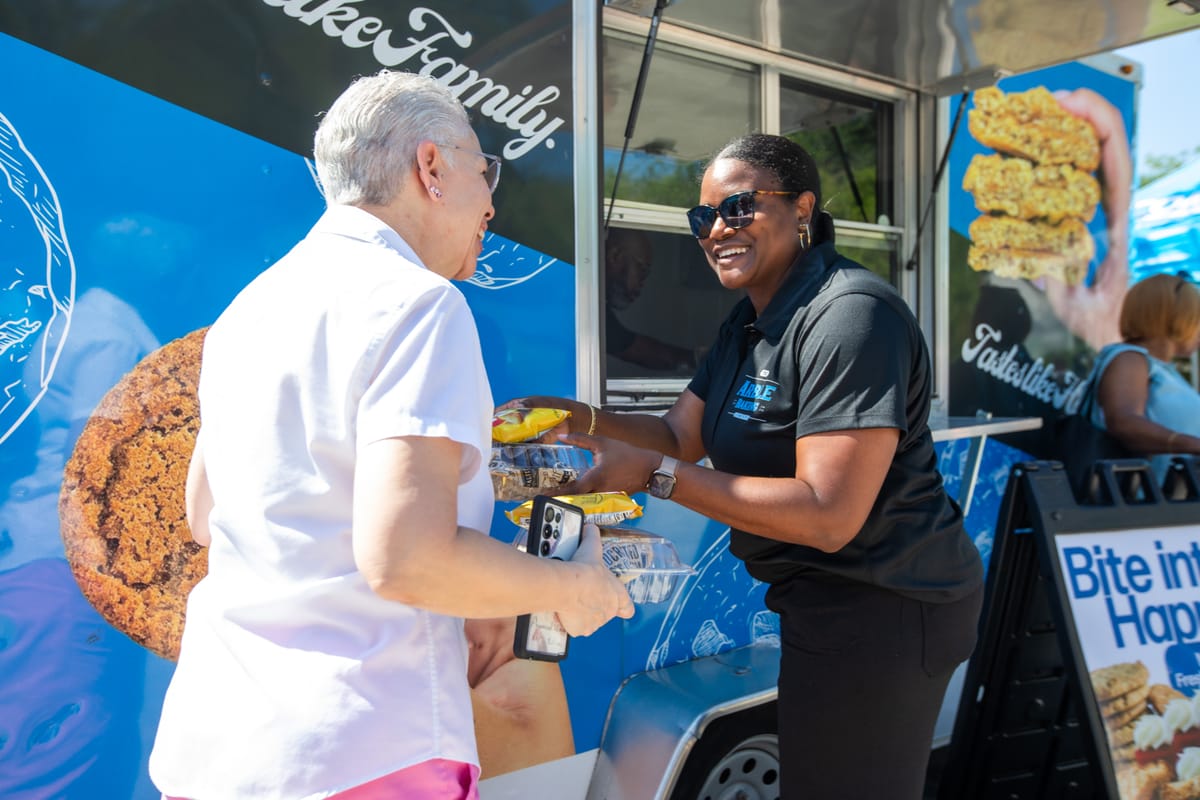 An Arble team member handing a fresh order to a guest at the food truck