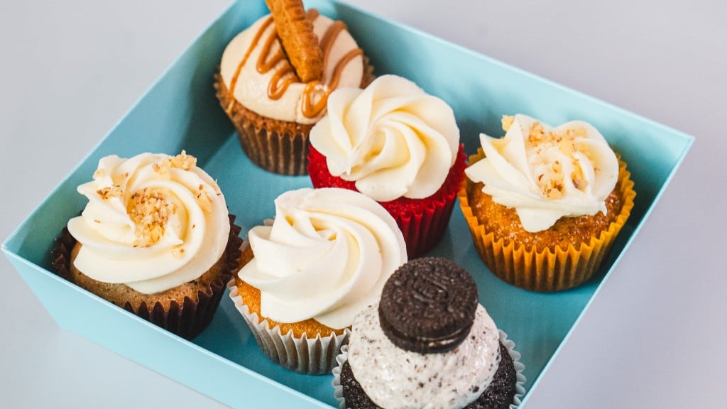 A blue bakery box with six assorted mini cupcakes, including cookie butter, red velvet, and cookies-and-cream