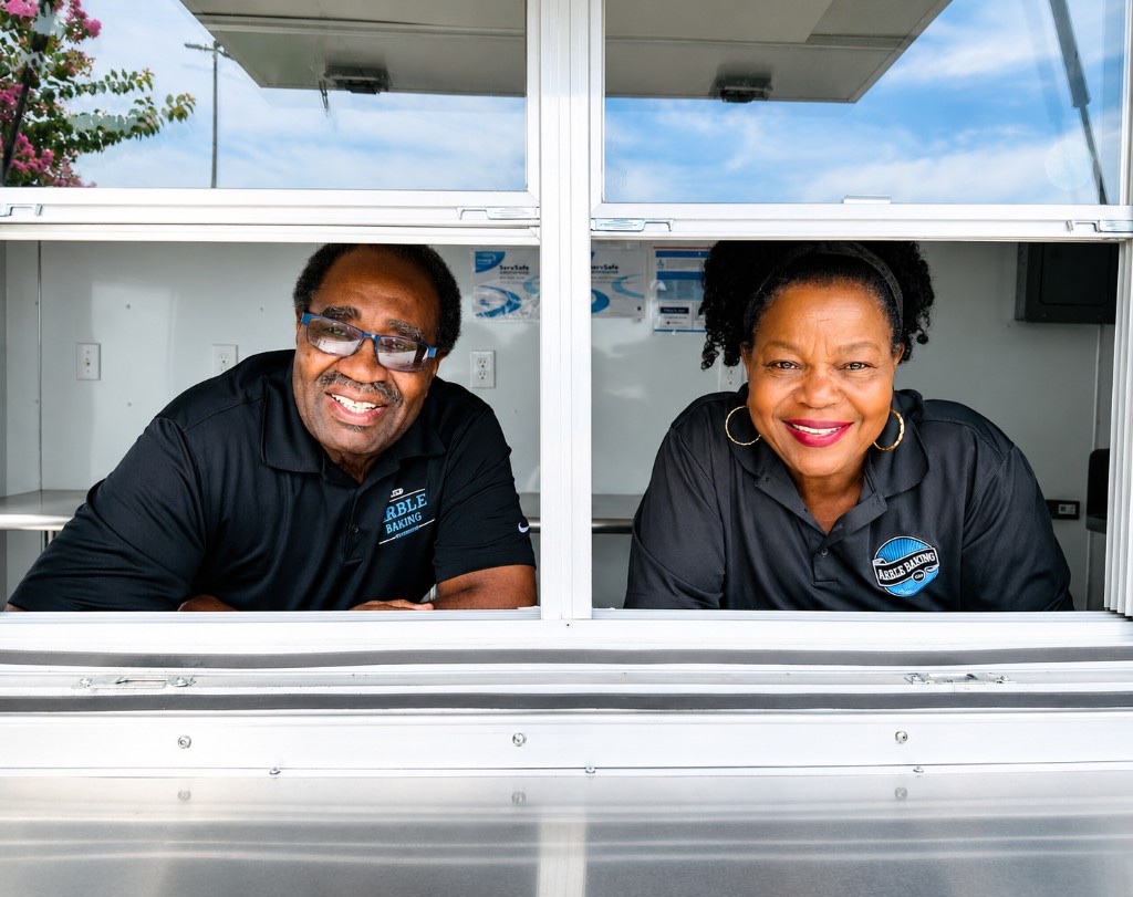 Veronica and Willis Anderson smiling together through the Arble food truck service window